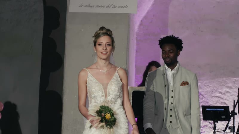 Sposa con bouquet e sposo in abito chiaro in passerella