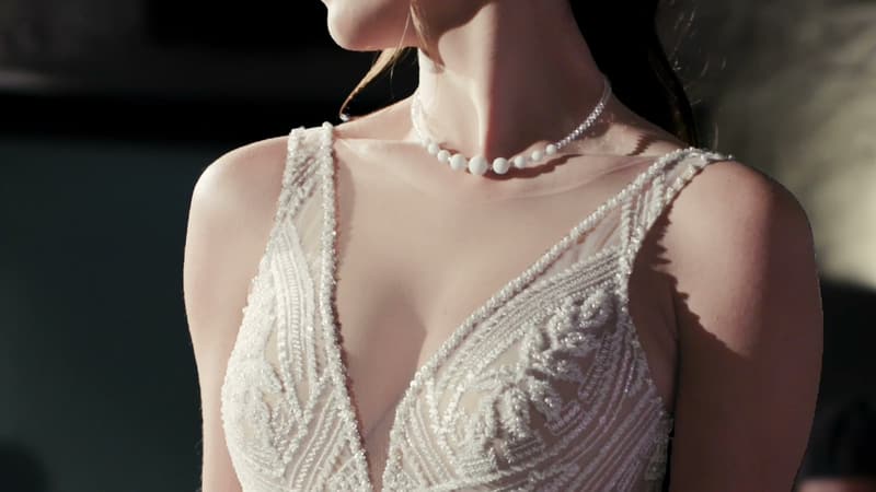 Dettaglio di un abito da sposa con collana di perle